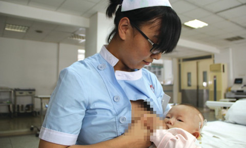 女护士为先心病女婴解衣喂奶 自己儿子吃辅食