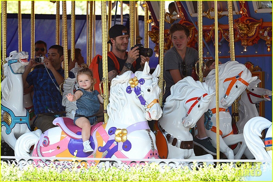 当地时间8月22日，加利福尼亚，贝克汉姆(David Beckham)和辣妹维多利亚带着他们的孩子游玩迪士尼，小贝充当摄影师为孩子们拍照，2岁的哈珀大摆姿势。