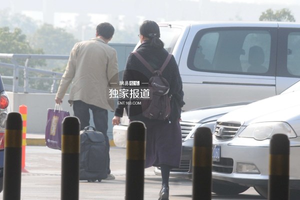 倪萍现身机场与司机热聊吞云吐雾