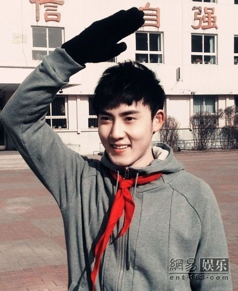 张睿系红领巾敬少年队礼。