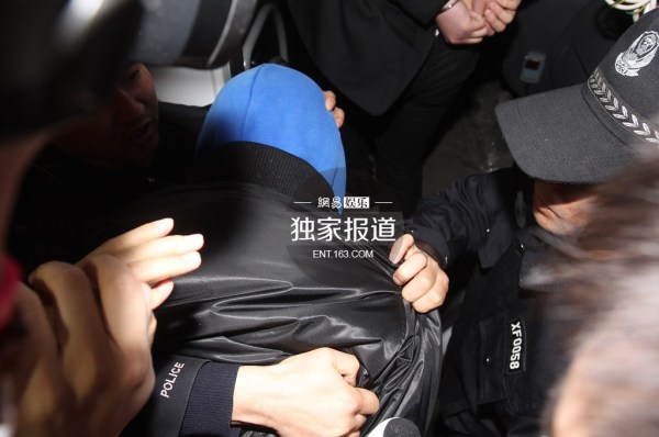 李代沫戴手铐离开派出所。