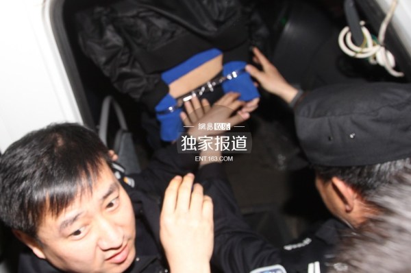 李代沫戴手铐离开派出所。