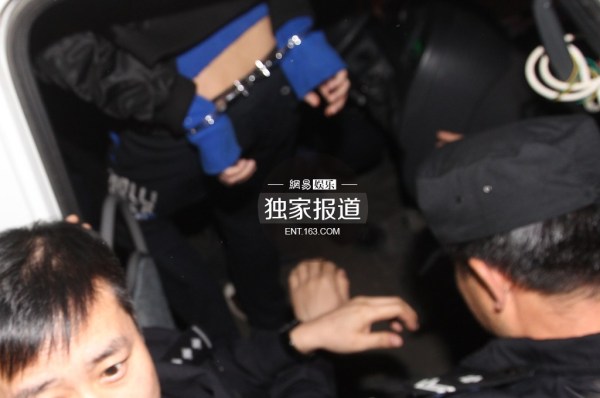 李代沫戴手铐离开派出所。