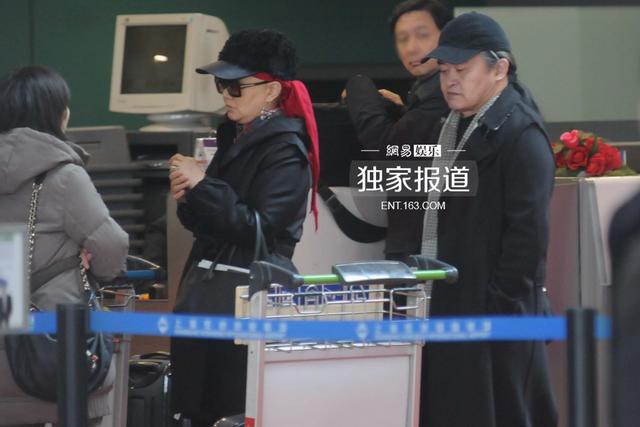 刘欢夫妇表情严肃现身机场 冷色调打扮无交流
