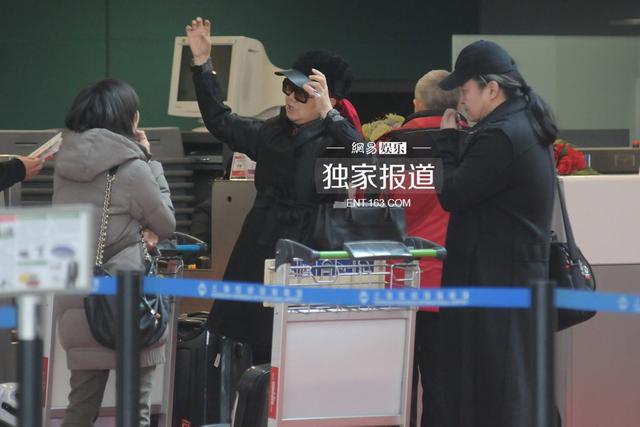 刘欢夫妇表情严肃现身机场 冷色调打扮无交流