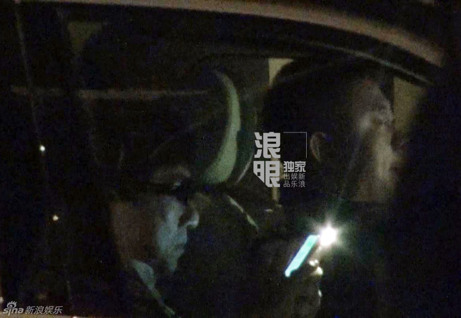 成龙坐车玩手机没关闪光灯 随后前往酒店