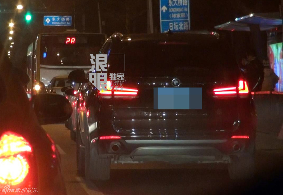 成龙坐车玩手机没关闪光灯 随后前往酒店