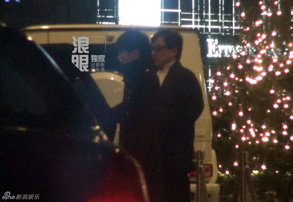 成龙坐车玩手机没关闪光灯 随后前往酒店