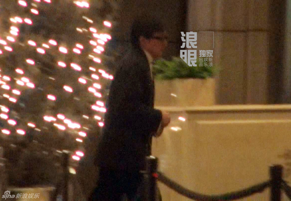 成龙坐车玩手机没关闪光灯 随后前往酒店