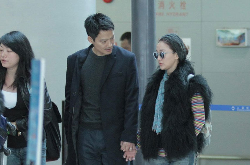 周迅潮范儿打扮现身机场 与老公十指紧扣秀恩爱